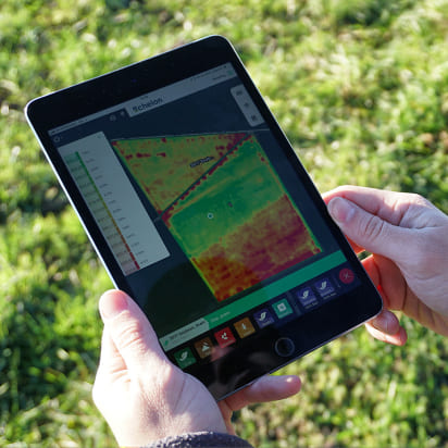 Son dos manos sosteniendo una tablet con una imagen de un mapa satelital 